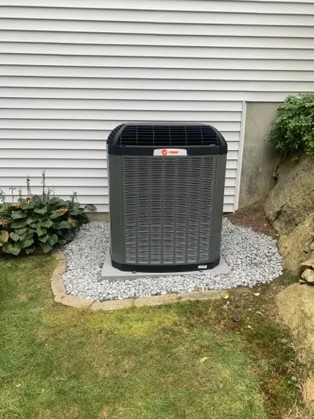 New air conditioning condenser surrounded by landscaping stone
