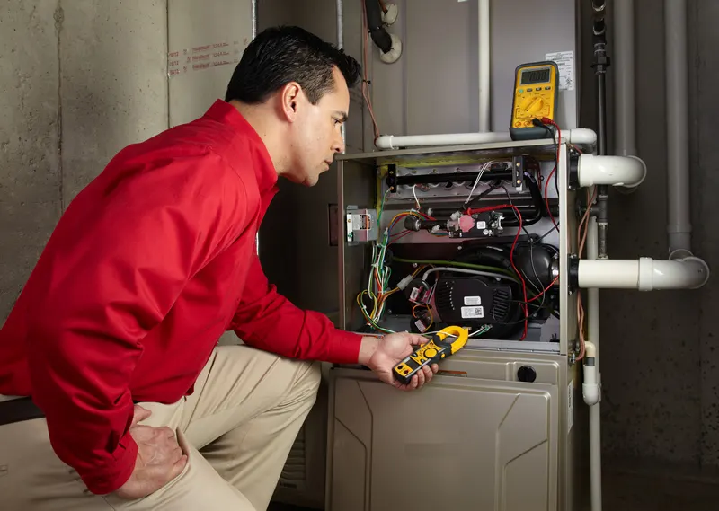 Technician checking a furnace with a meter