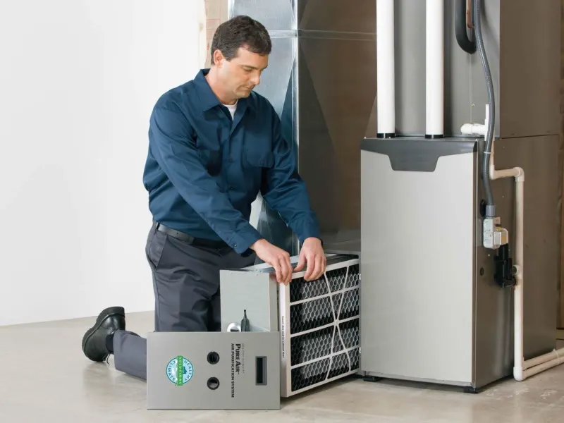 Technician servicing a furnace and air filter