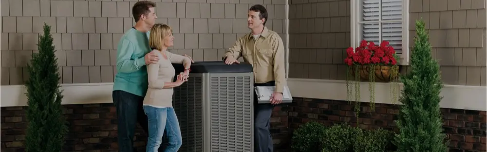 Technician and homeowners talking beside an air conditioner